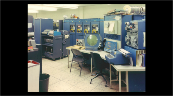 Foto del mismo ordenador, rodeado de armarios de periféricos