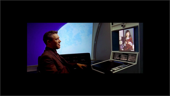 Captura de una película de ciencia ficción no determinada. Un hombre habla con una niña por videoconferencia